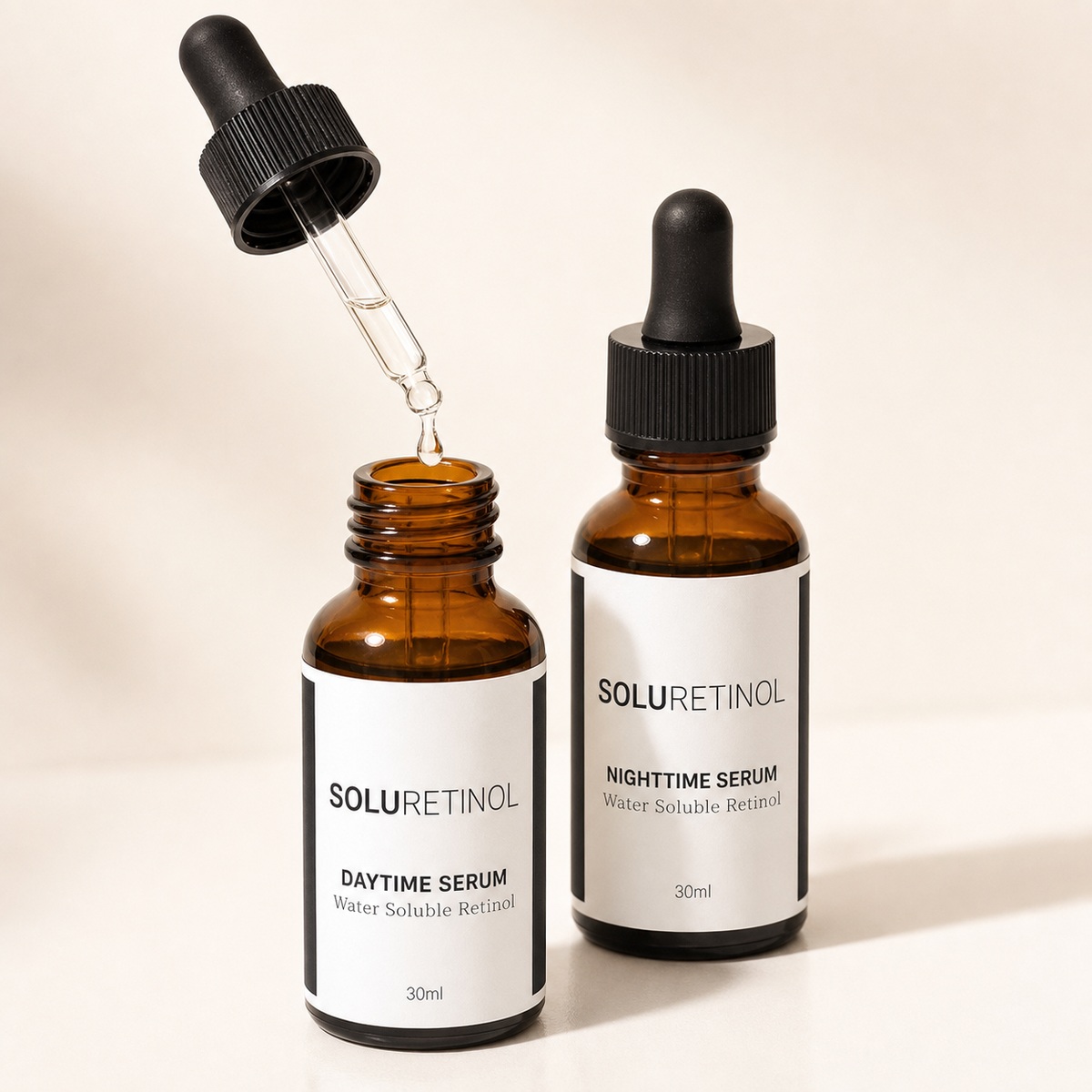 SoluRetinol Daytime Serum with dropper lifted and a single drop falling, Nighttime Serum bottle beside it